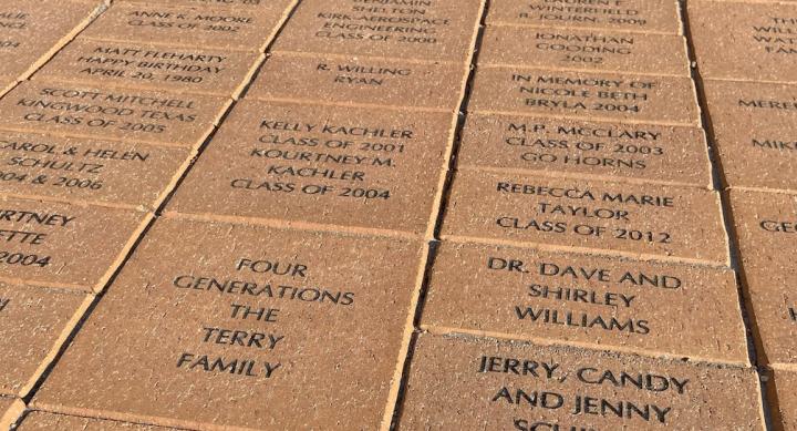 Detail of brick pavers etched with student and family names in front of UT’s Student Services Building